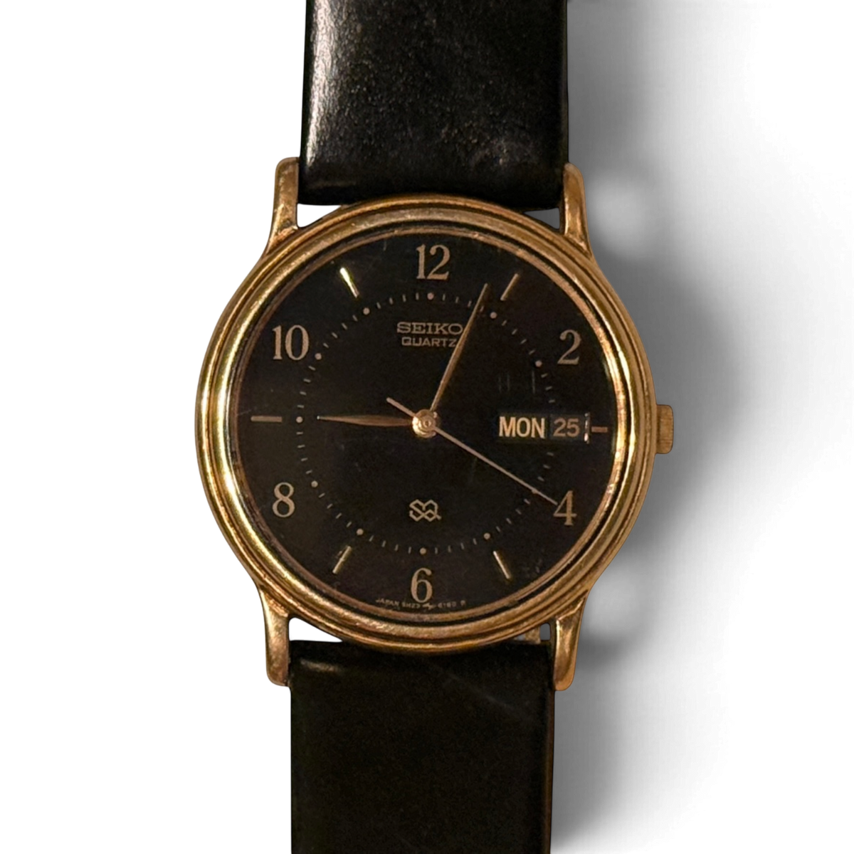 Primer plano de la esfera negra del Seiko SQ 5H23-6280, con índices de barra dorados y el día y la fecha en inglés a las tres