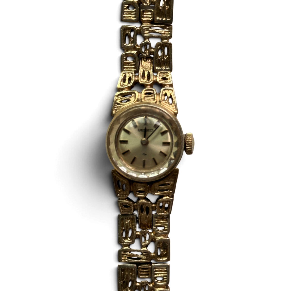 Close-up of the Seiko 11-0549 champagne dial with stick indexes and gold-tone crown