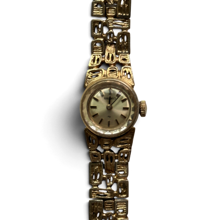 Close-up of the Seiko 11-0549 champagne dial with stick indexes and gold-tone crown
