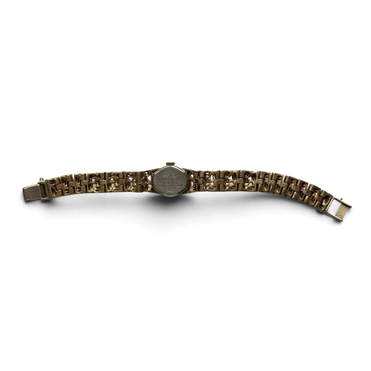 Seiko 11-0549 laid flat, showing the full gold-tone bracelet and the stainless steel caseback